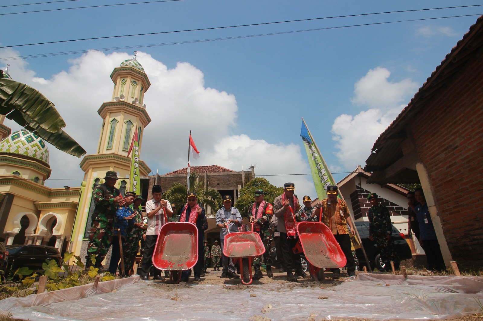 DIMULAI: Pj Bupati Jepara Edy Supriyanta bersama jajaran Forkopimda Jepara menuangkan adonan semen ke ruas jalan yang akan dicor dalam TMMD. (MOH. NUR SYAHRI MUHARROM/RADAR KUDUS)