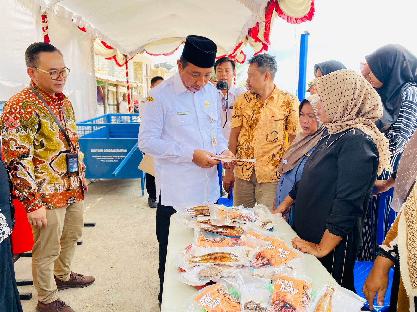 CEK KUALITAS: Bupati Rembang Abdul Hafidz melihat langsung ikan asap dalam kemasaan saat peresmian Kampung Madani kemarin (21/2). (PROKOMPIMDA UNTUK RADAR KUDUS)