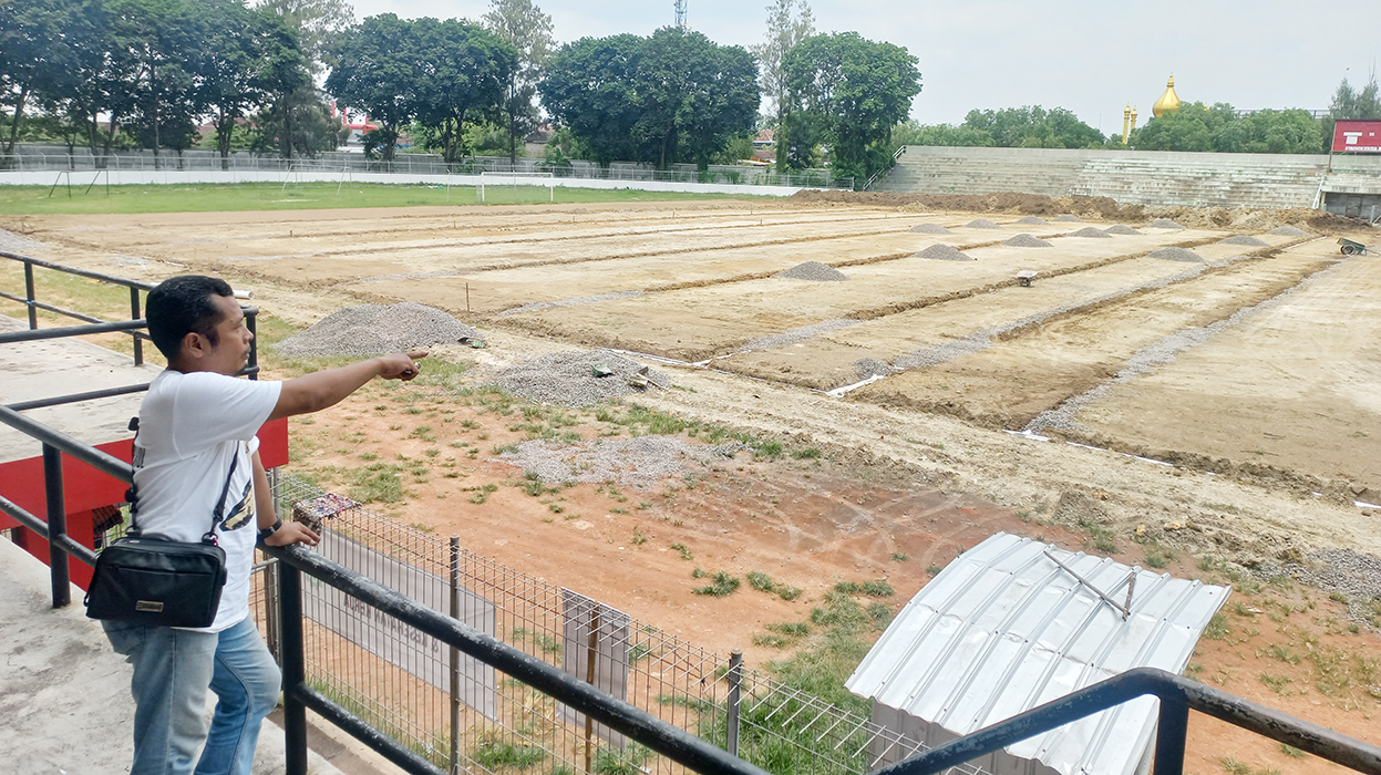 PANTAU: Pelaksana dari CV Simpatik Karya Mandiri, Wahyu Budiono tinjau pengerjaan proyek rehabilitasi Stadion Krida Bhakti Purwodadi kemarin.