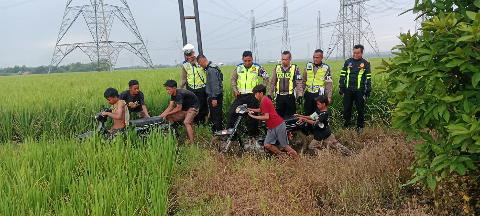 TERCIDUK: Satlantas Polres Grobogan menggiring para remaja pelaku balap liar yang kabur ke sawah kemarin.