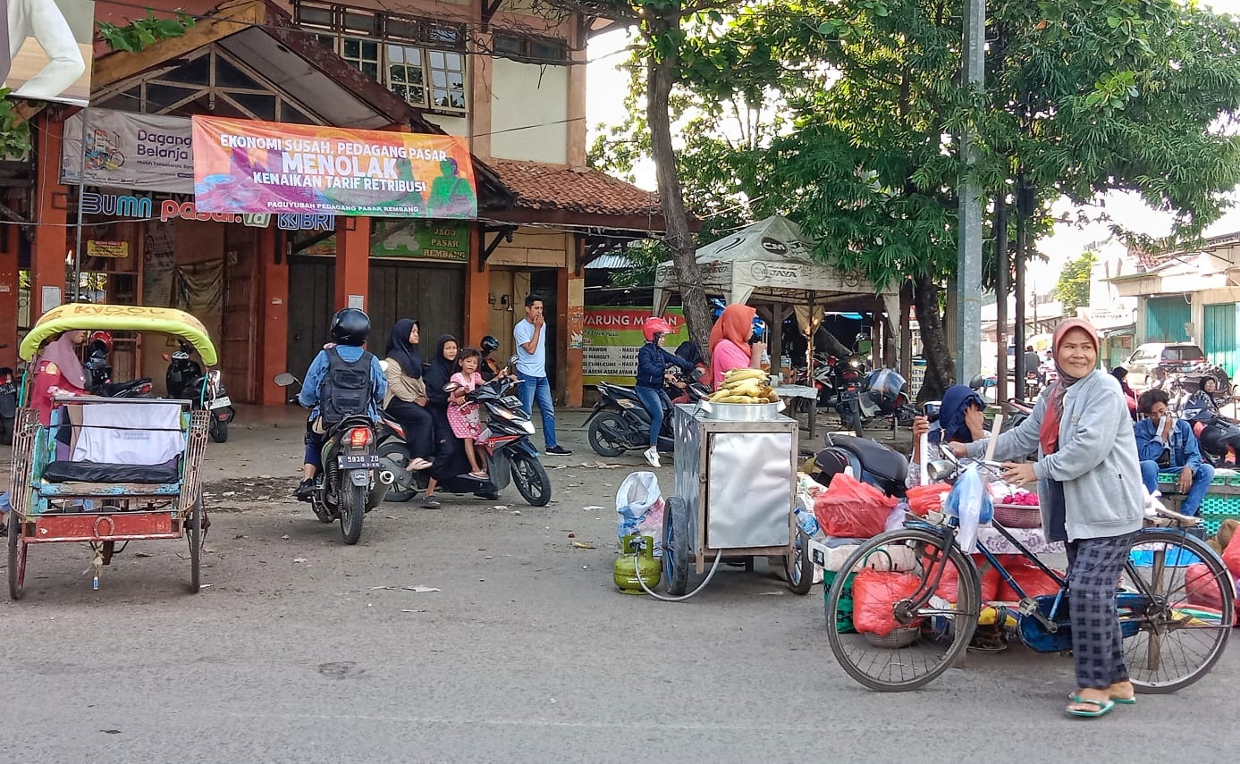 BANNER PENOLAKAN: Banner bertuliskan narasi keberatan atas kenaikan retribusi terpasang di depan Pasar Rembang