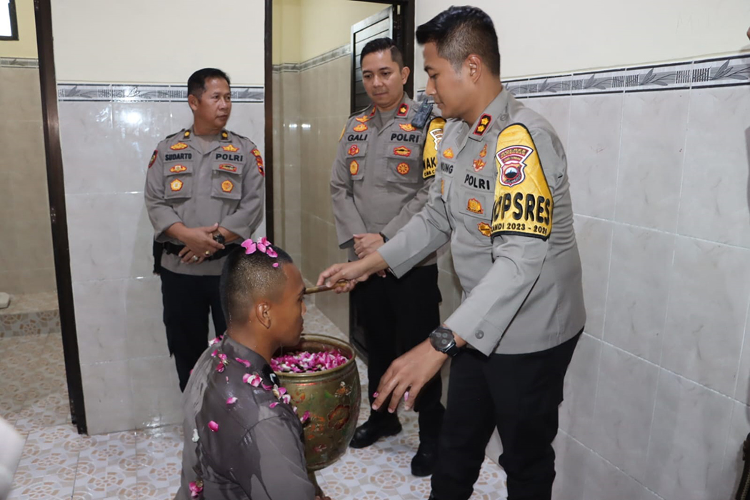 MANDI KEMBANG: Kapolres Grobogan AKBP Dedy Anung Kurniawan mengguyur air bunga kepada anggota Bintara Polres Grobogan dalam menempati barak di Mapolres setempat kemarin.