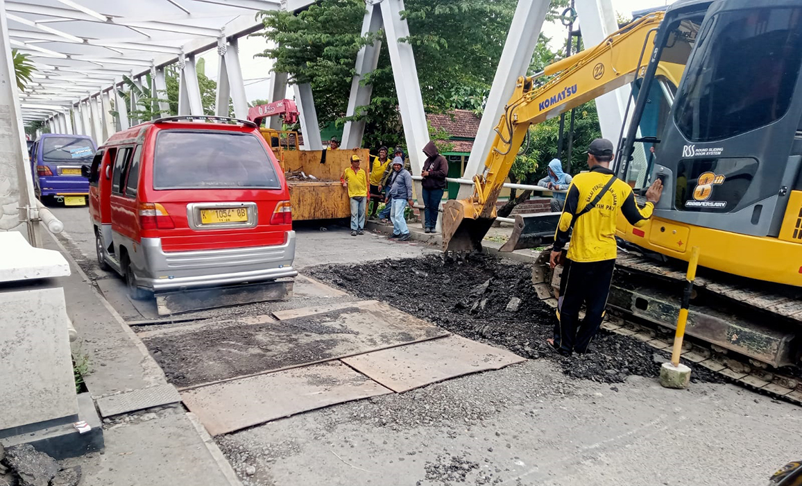 DIKEBUT: Pekerja memperbaiki lantai jembatan Babalan, Kecamatan Undaan.