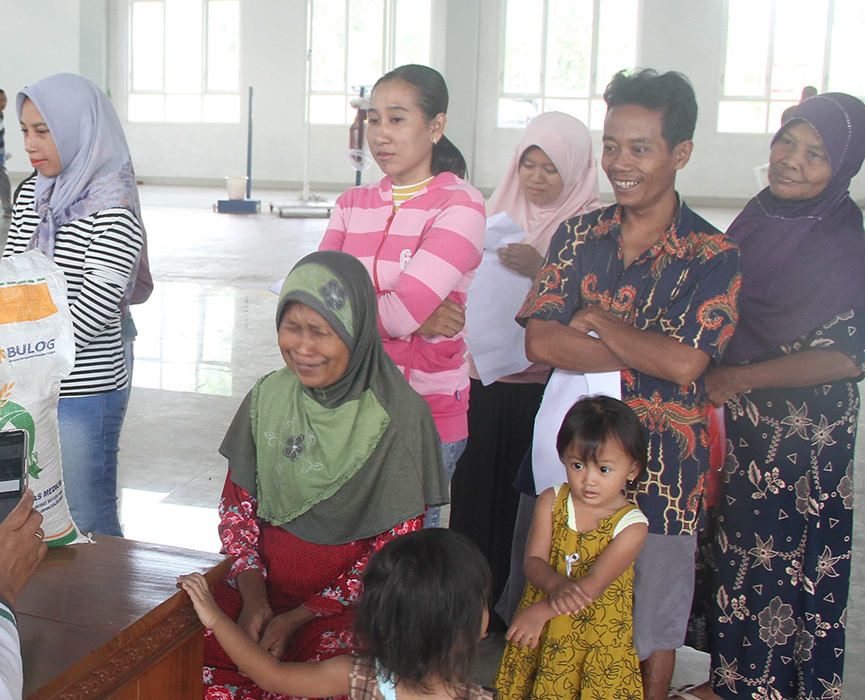 BERDAYAKAN KPM : Beberapa keluarga penerima manfaat (KPM) di wilayah Kecamatan Dawe saat antre untuk mengambil bantuan.