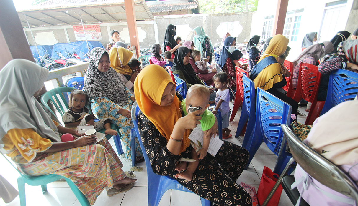 GEMATI: Seorang ibu asal Kecamatan Kedung menyuapkan segelas susu bagi bayinya untuk mencegah stunting belum lama ini.