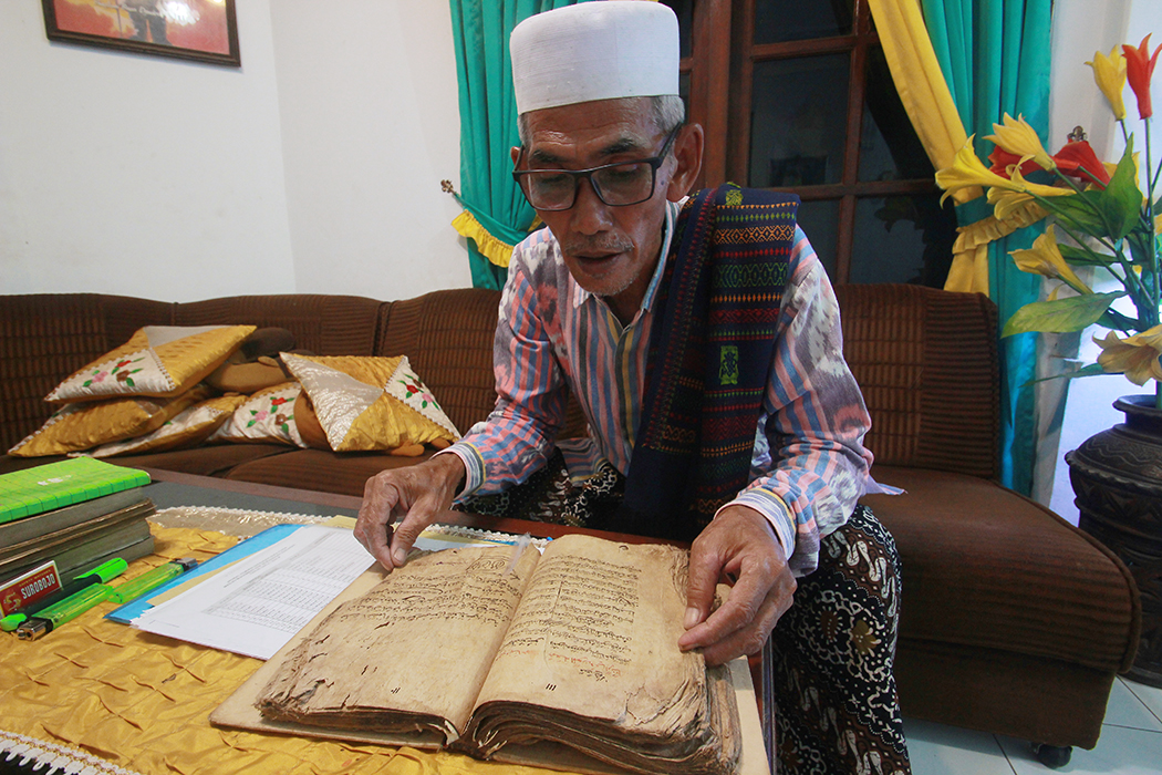 PENINGGALAN: Ketua Takmir Masjid, Abdun Nasir membaca kitab peninggalan Mbah Muhammad Arif, sosok pendiri Masjid Jamik Muhammad Arif.