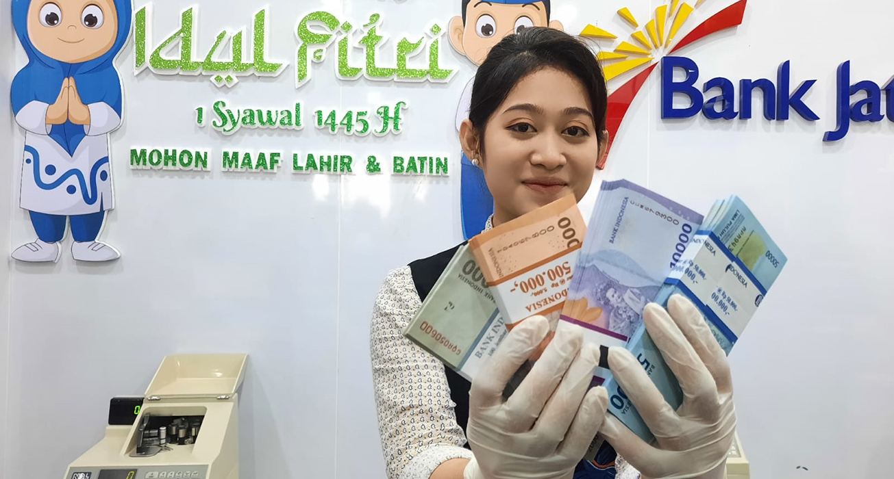 UANG BARU: Teller Bank Jateng Cabang Kudus Evita memperlihatkan pecahan uang baru kemarin.