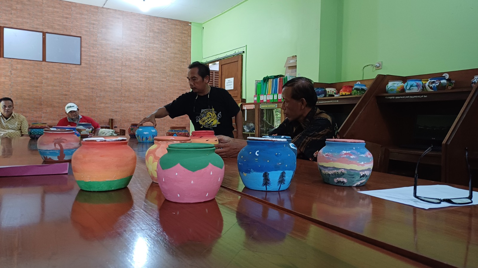 HASIL KARYA: Seorang juru melihat lukisan gerabah hasil karya anak SMP se-Kabupaten Jepara pada saat diadakannya lomba melukis gerabah di SMK 2 N Jepara. (NIBROS HASSANI/JAWA POS RADAR KUDUS)