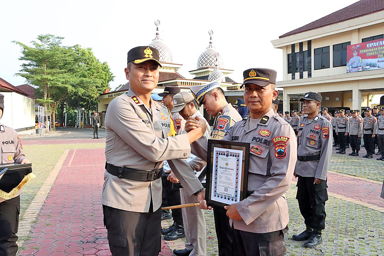 BERIKAN PENGHARGAAN: Kapolres Grobogan AKBP Dedy Anung Kurniawan memberikan penghargaan kepada anggota berprestasi usai apel pagi di mapolres setempat, kemarin.  (SIROJUL MUNIR/RADAR KUDUS )