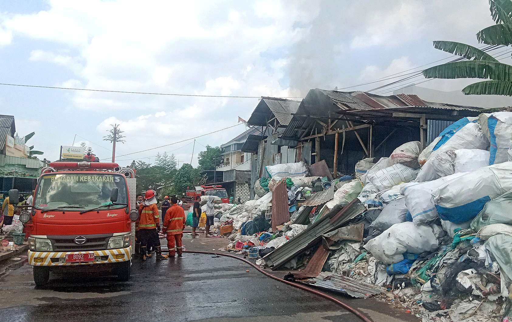 PEMADAMAN: Tim Damkar Rembang berada di sekitar gudang rosok yang berada di Dukuh Grajen, Desa Sumberjo saat terjadi kebakaran kemarin. (VACHRI RINALDY L/RADAR KUDUS)