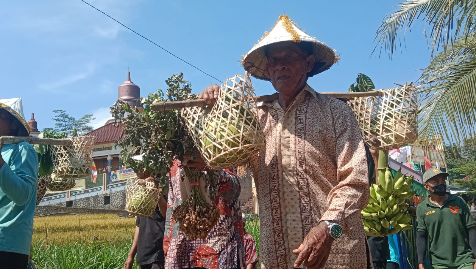 BUDAYA: Warga memikul tlandik berisi nasi berkatan untuk didoakan dalam prosesi sedekah bumi Desa Jrahi, Gunungwungkal, Pati, kemarin. (ACHMAD ULIL ALBAB/RADAR KUDUS)