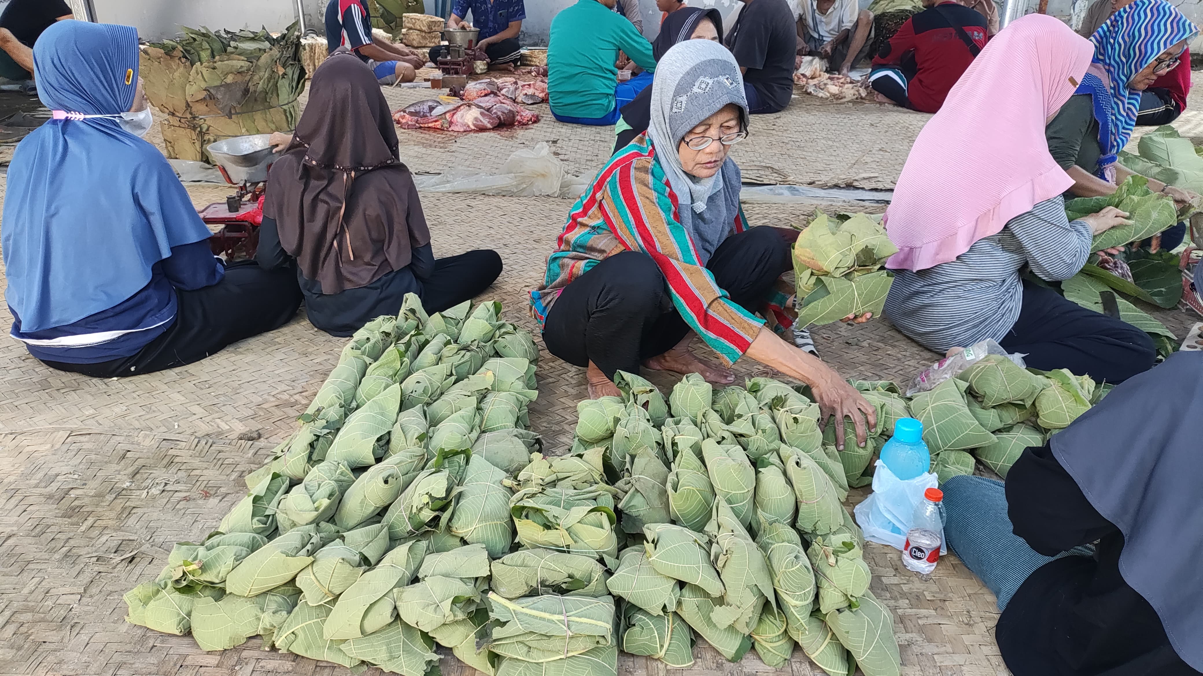 NILAI TERTINGGI: Perewang mengemasi daging kurban dengan daun jati lalu dibagikan kepada masyarakat. (GALIH ERLAMBANG W/ RADAR KUDUS)