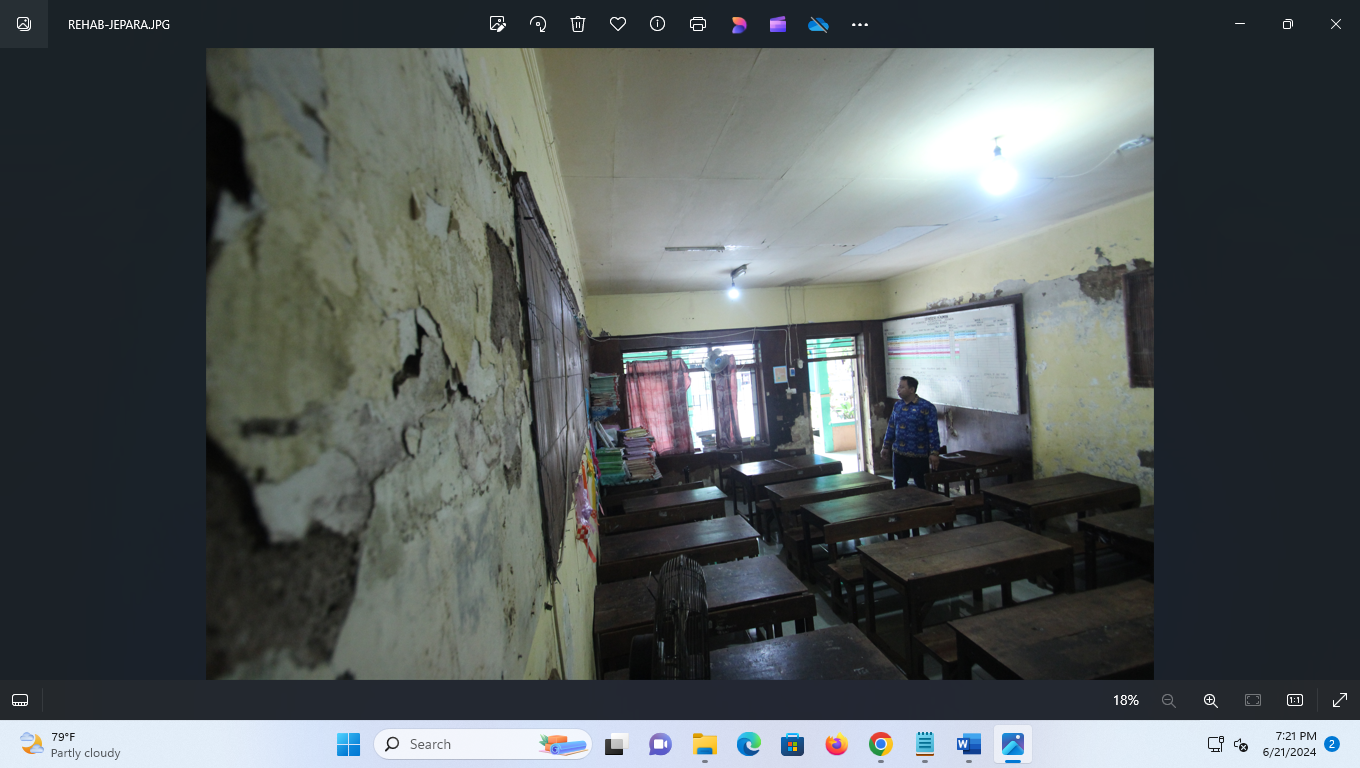 MEMPRIHATINKAN: Salah satu guru mengecek tembok ruangan kelas yang sudah mengelupas. (MOH. NUR SYAHRI MUHARROM/RADAR KUDUS)