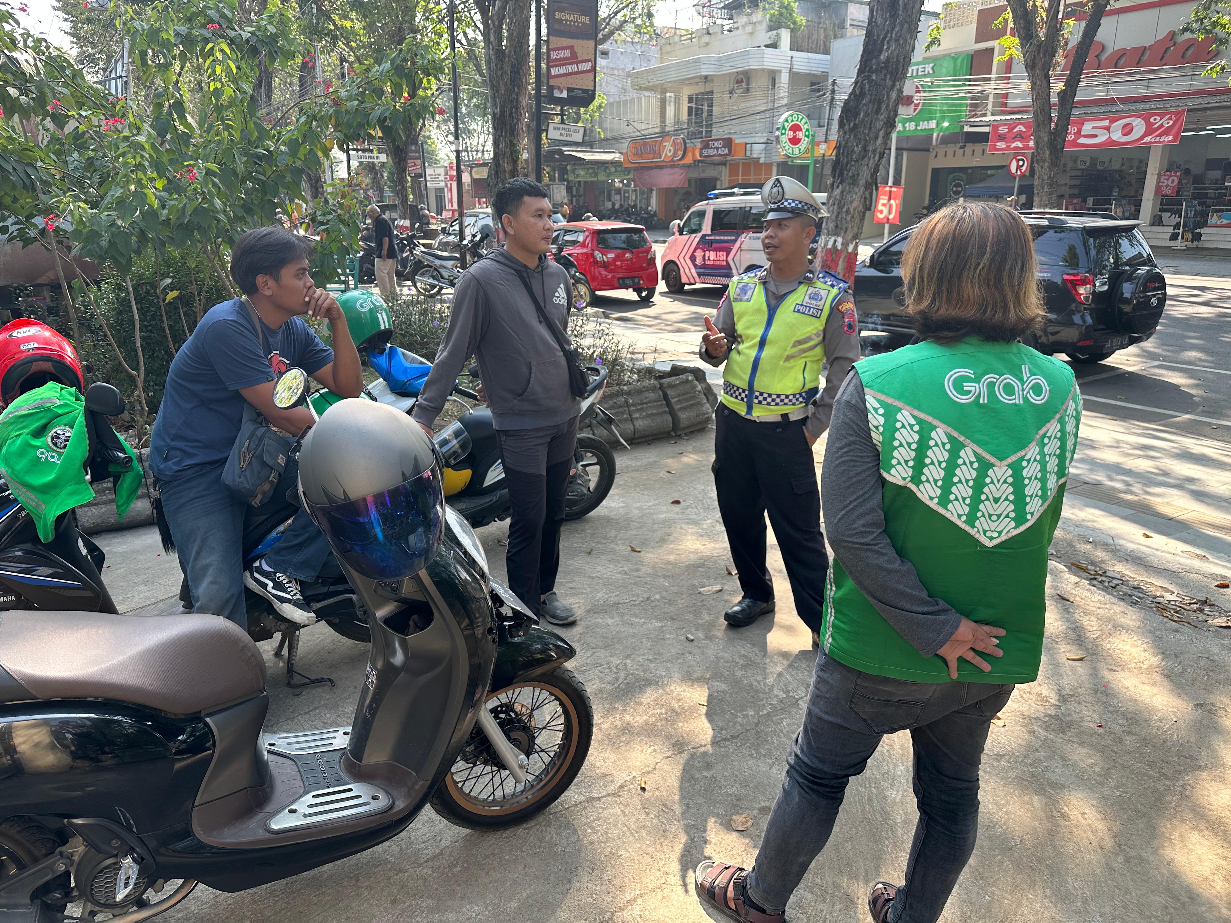 SOSIALISASI: Personel unit Kamsel Satlantas Polres Grobogan menyosialisasikan tertib berlalulintas ke sejumlah  driver ojek online (ojol) di Kota Purwodadi. (INTAN MAYLANI SABRINA/RADAR KUDUS)