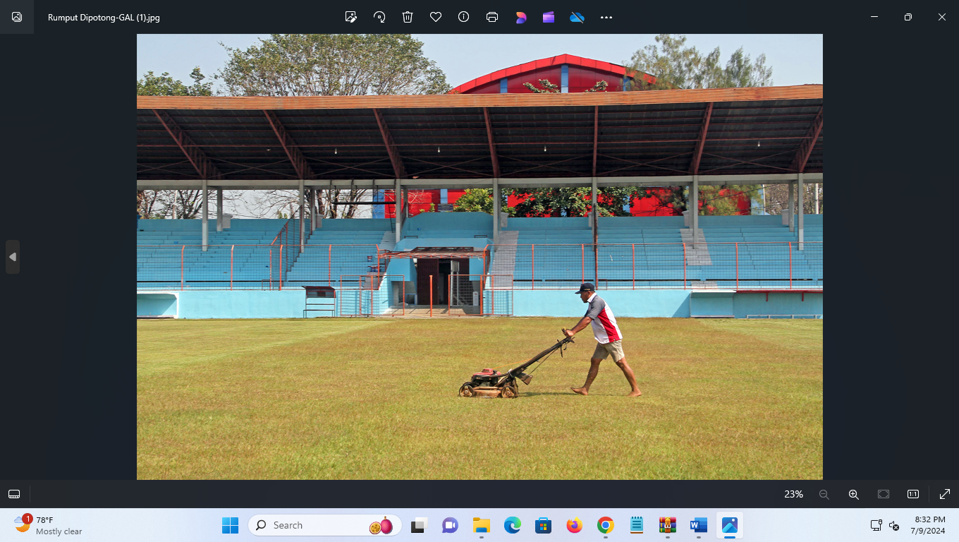 DIKEBUT: Pekerja memotong rumput Stadion Wergu Wetan dan warna tribun sudah berganti biru. (GALIH ERLAMBANG W/ RADAR KUDUS)