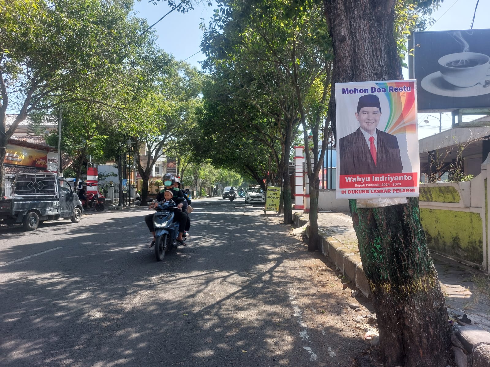 TAK RAMAH LINGKUNGAN: Selembar alat peraga kampanye (APK) tertancap pohon di wilayah perkotaan Pati kemarin sore. (ANDRE FAIDHIL FALAH/RADAR KUDUS)