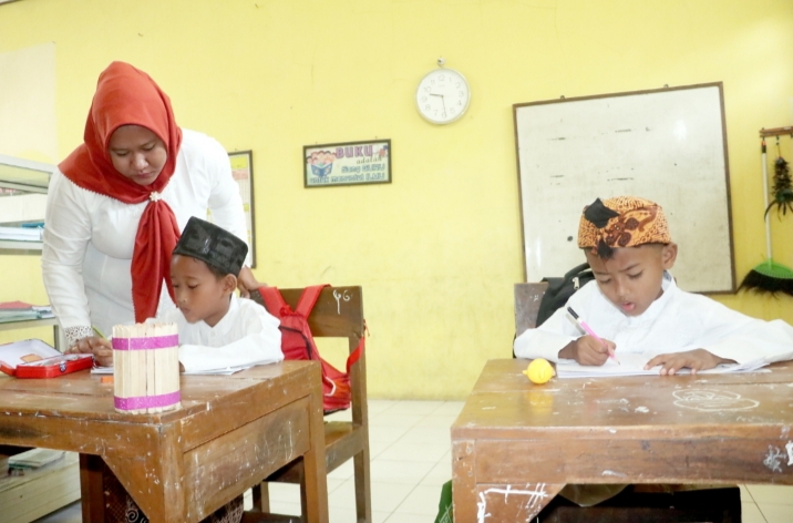 CUMA DAPAT DUA SISWA: Guru mengajar dua siswanya di ruang kelas disekat di SD 2 Bulungcangkring Jekulo Kudus kemarin. DONNY SETYAWAN/RADAR KUDUS