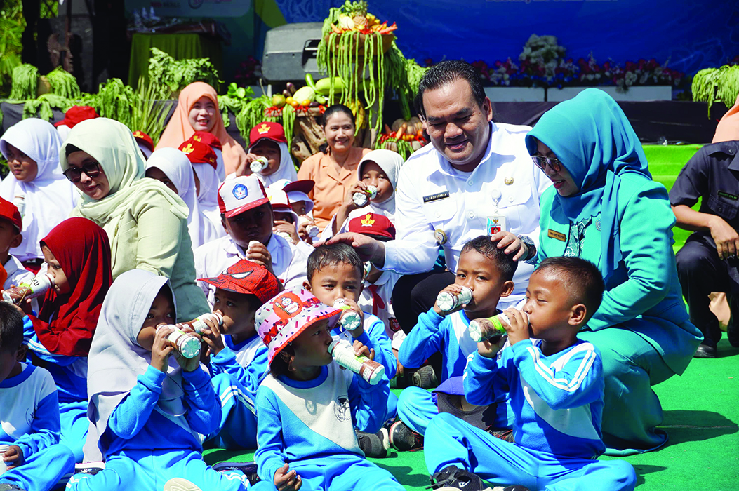TAMBAH GIZI: Bupati Blora Arief Rohman (dua dari kanan) bersama istri, Ainia Sholichah (kiri) mendampingi anak-anak minum susu saat Hari Anak Nasional kemarin.(HUMAS PEMKAB BLORA UNTUK RADARPATI.ID)