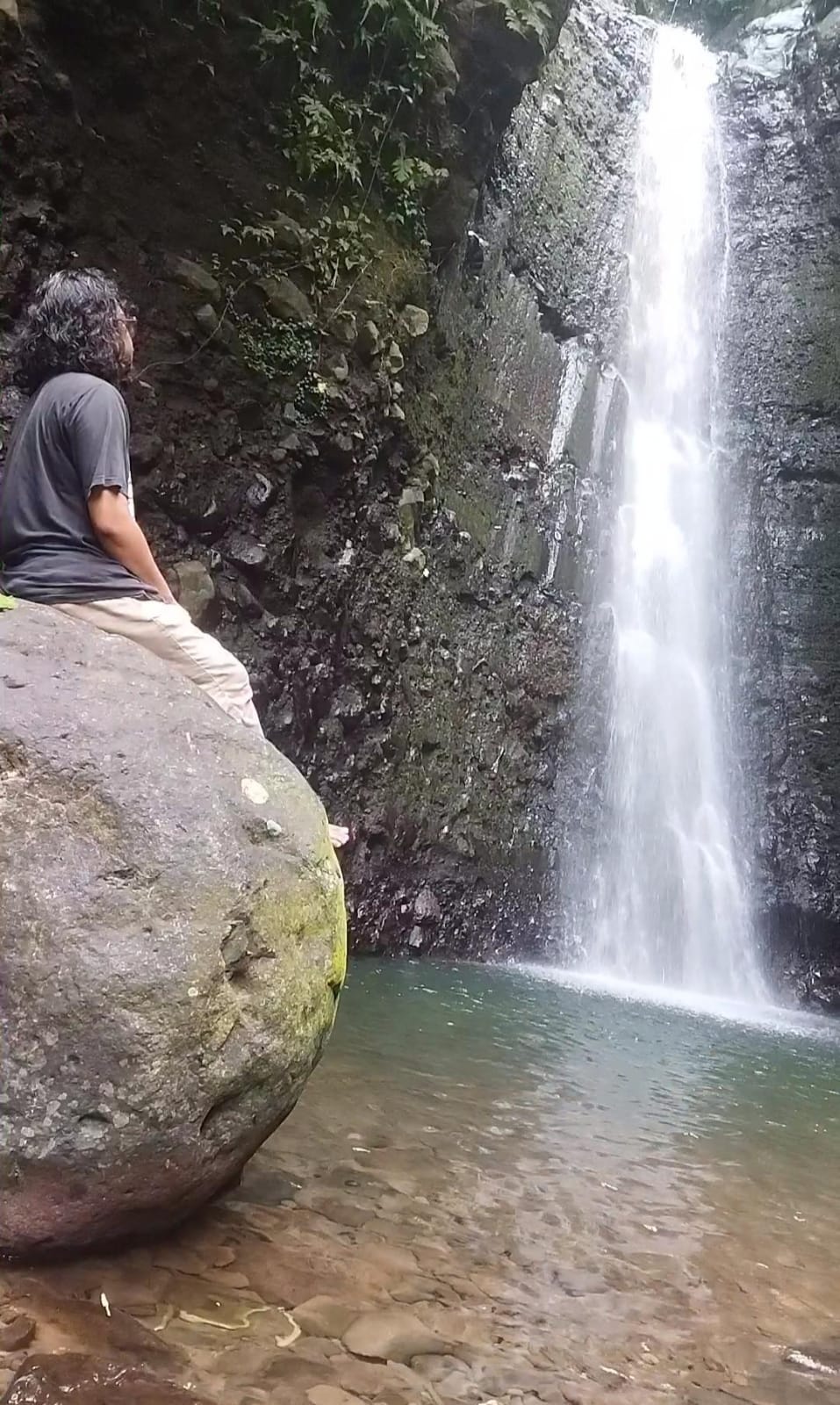 SEJUK: Wisatawan, Mahendra, 34, menikmati kesegaran air terjun Kedung Gender, Desa Dukuhwaringin, Kecamatan Dawe, Kudus, (21/7).