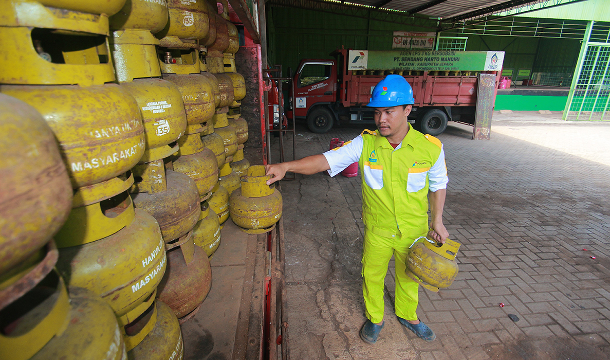 STABIL: Petugas sebuah agen elpiji di Desa Kuwasen, Kecamatan Kota Jepara menata tumpukan tabung elpiji melon sebelum didistribusikan ke pangkalan. (MOH. NUR SYAHRI MUHARROM/RADARPATI.ID)