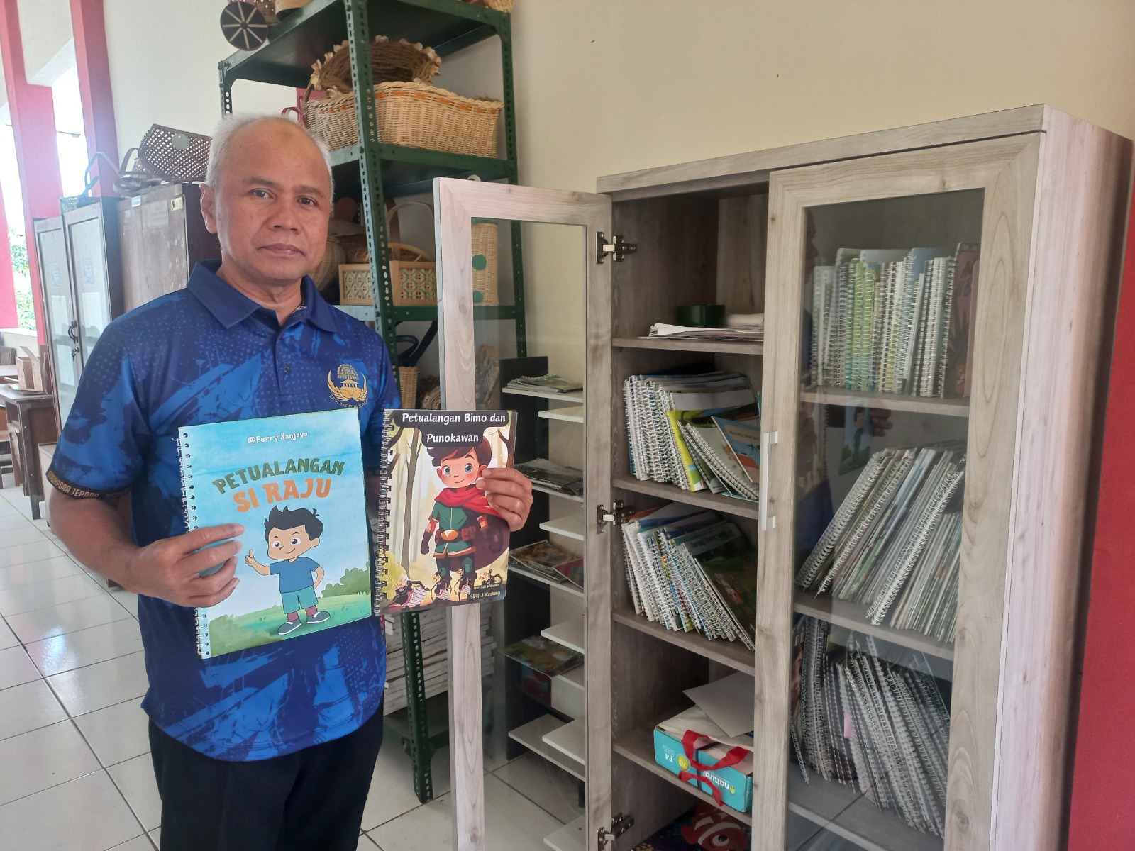 BERGAMBAR: Kabid Sekolah Dasar Dinas Pendidikan Pemuda dan Olahraga (Disdikpora) Jepara Edi Utoyo tunjukkan buku-buku karya guru SD se-Kabupaten Jepara, Kamis (15/8). (FIKRI THOHARUDIN/RADAR KUDUS)