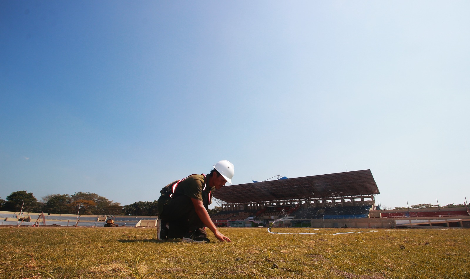 KEBUT: Petugas mengecek kondisi rumput lapangan Stadion GBK Jepara yang baru saja ditanam. (MOH. NUR SYAHRI MUHARROM/RADAR KUDUS)
