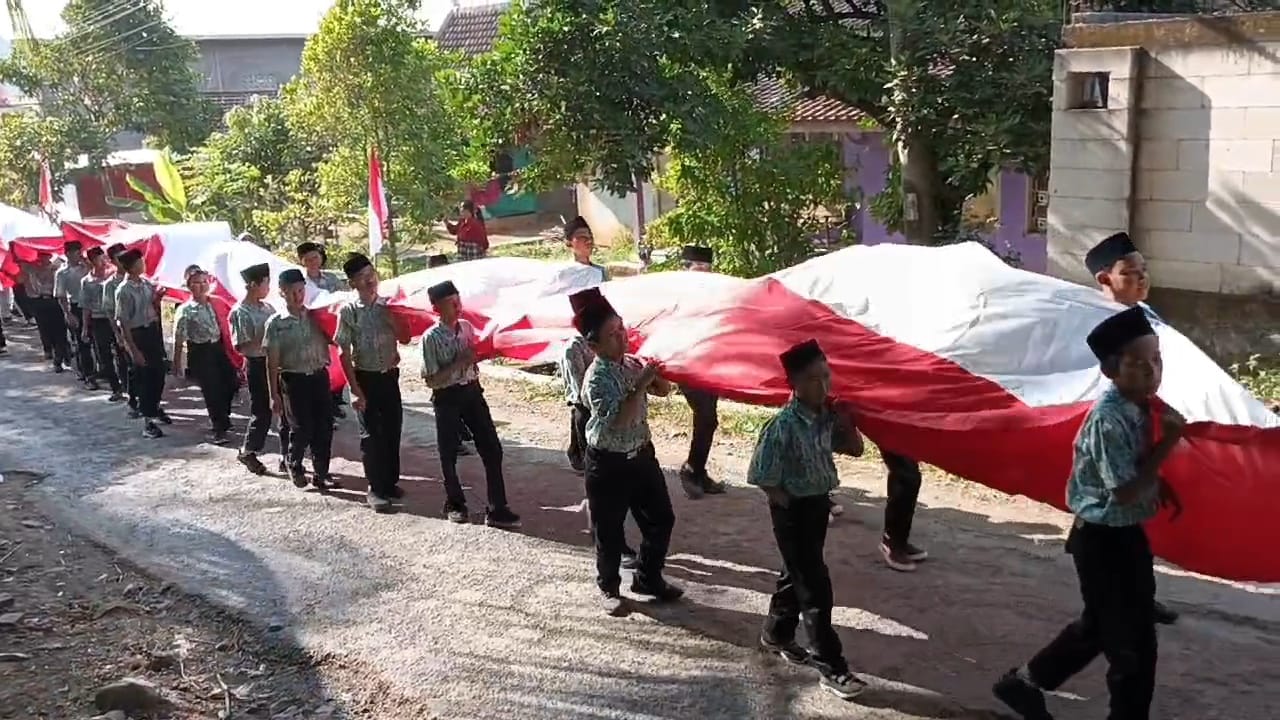 DIGOTONG: Siswa-siswi sekolahan di Kecamatan Gunungwungkal membawa bendera merah putih melintasi jalan Desa Giling, Gunungwungkal (16/8). (ANDRE FAIDHIL FALAH/RADAR KUDUS)   &nbsp;