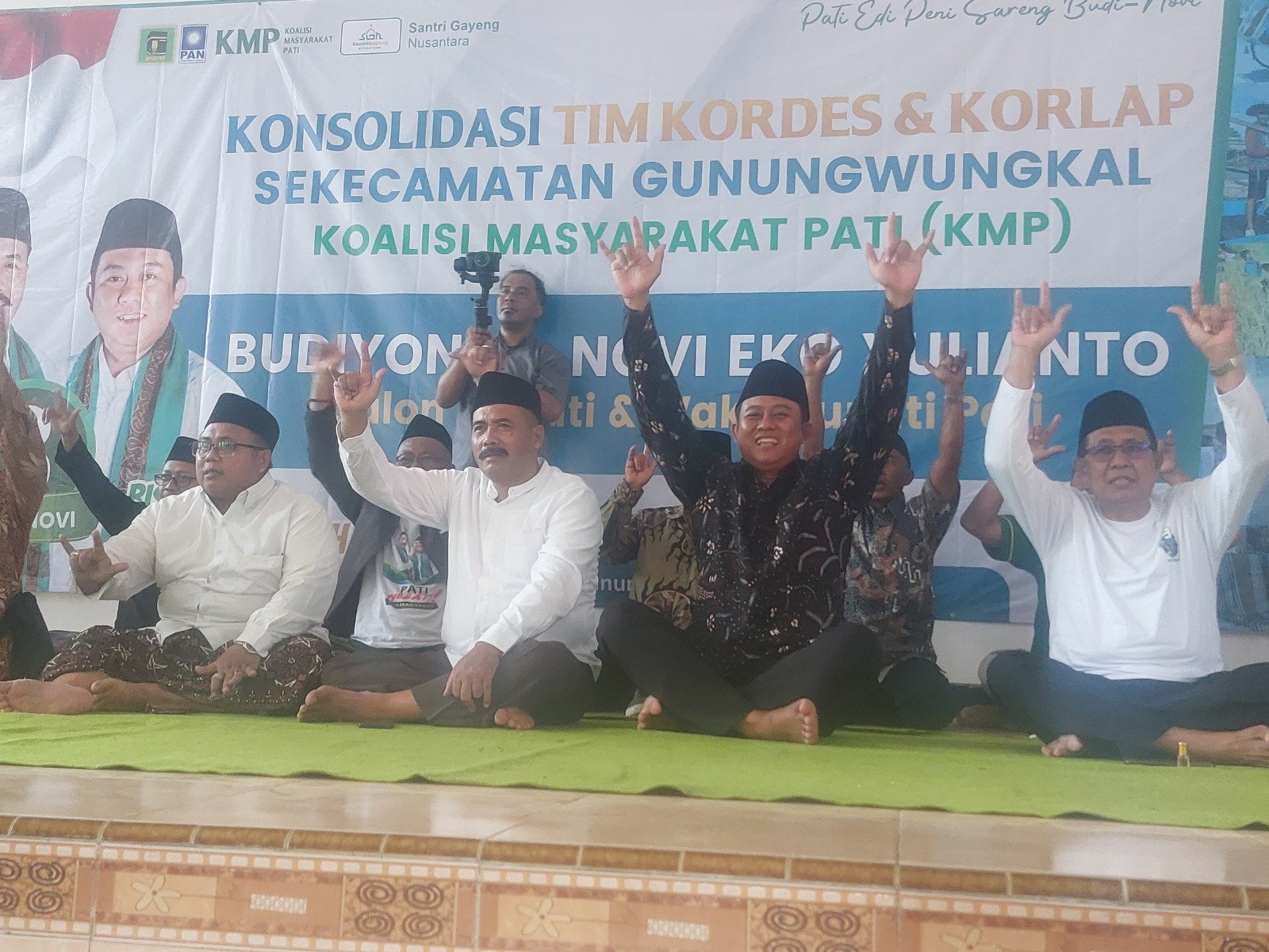 DUDUK BARENG: Paslon bupati dan wakil bupati Pati Budi-Novi menunjukkan salam metalnya kepada para simpatisan di wilayah Gunungwungkal. (ANDRE FAIDHIL FALAH/RADAR KUDUS)