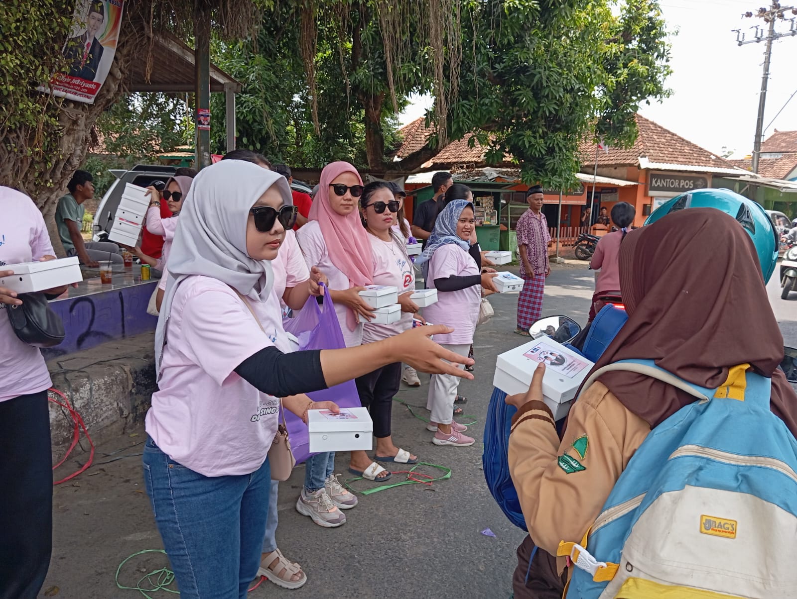 RAMAH : Tim Arimbi Pati membagikan paket makanan dan minuman kepada pengendara yang melintas di pertigaan pohon beringin Tlogowungu. (ACHMAD ULIL ALBAB/RADAR KUDUS)