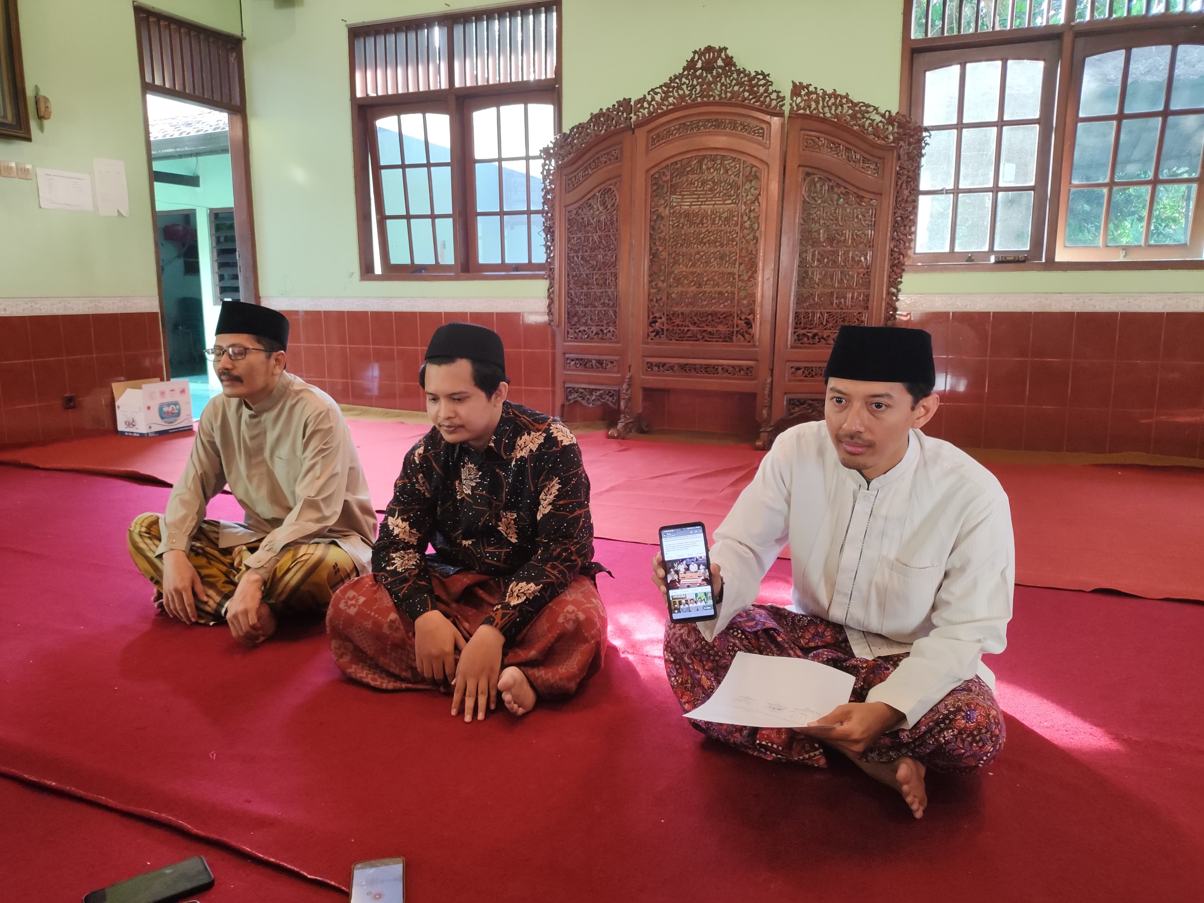 BERI PENJELASAN: Muhammad Fahri (kanan) menunjukkan foto unggahan di sosial media didampingi oleh Naufal Annabil (tengah) dan Gus Hana (21/10). (GALIH ERLAMBANG W/ RADAR KUDUS)   &nbsp;