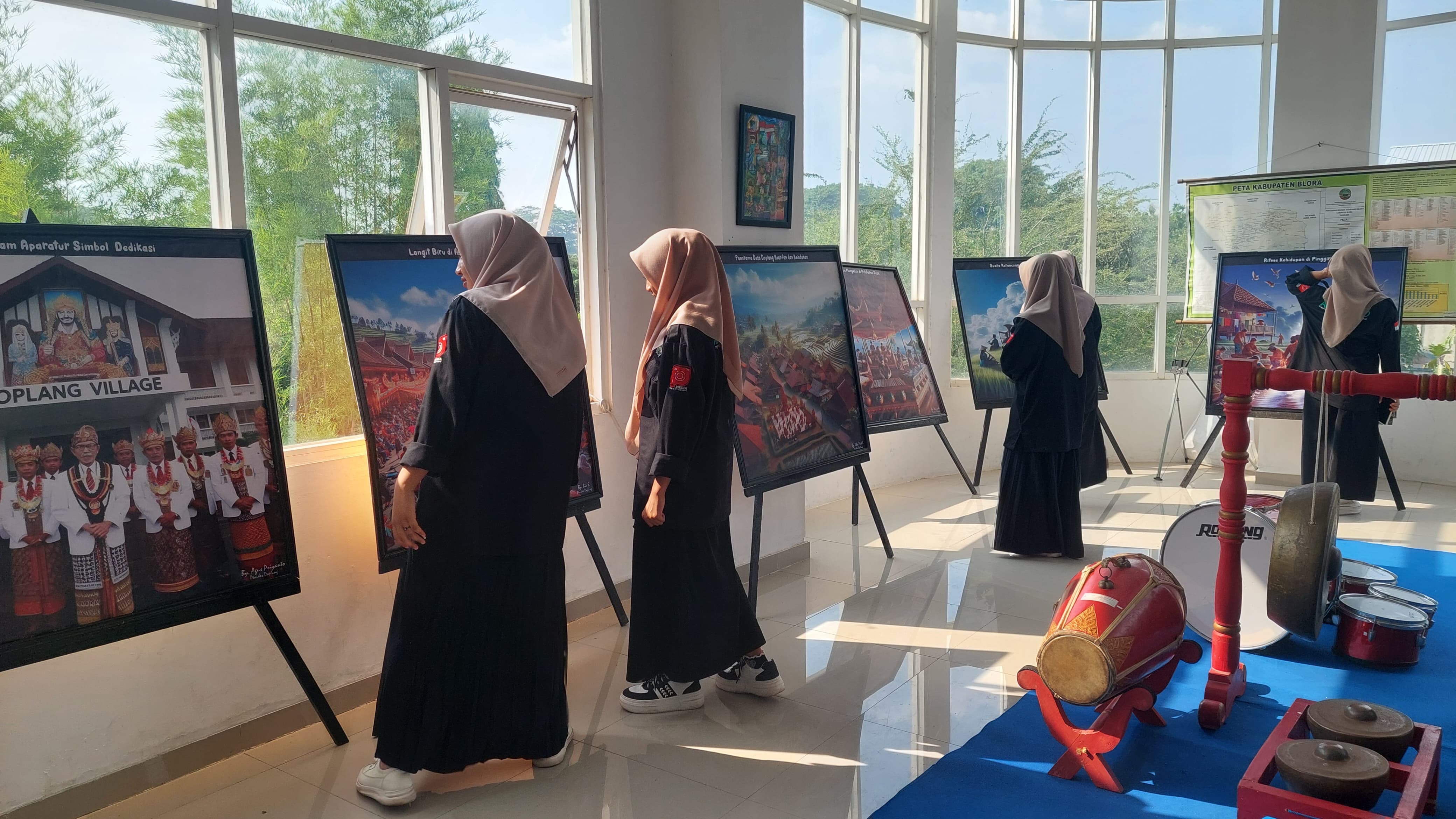 PAMERAN: Para pelajar melihat lukisan yang dibuat dari hasil AI, lukisan itu dipamerkan di Perpustakaan Blora. (ARIF FAKHRIAN KHALIM/RADARPATI.ID)