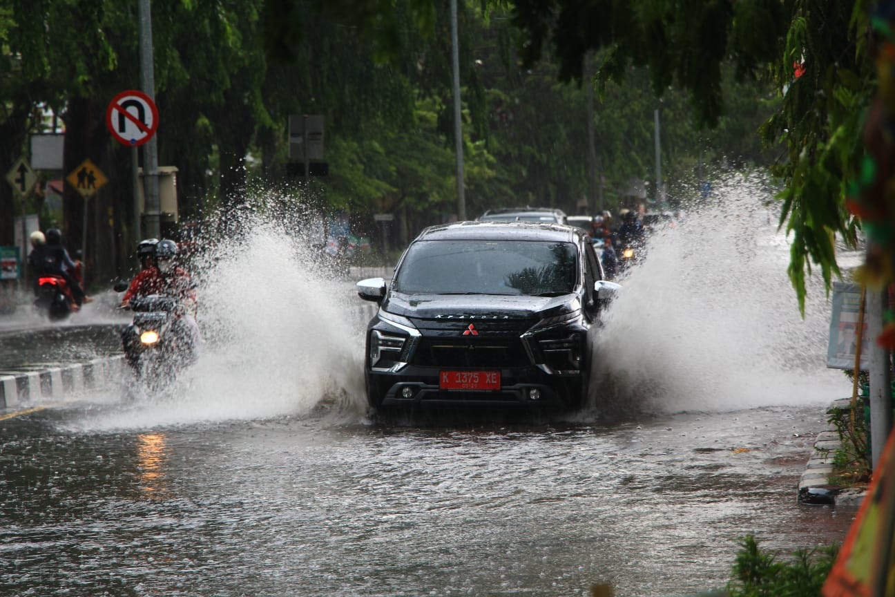 TERJANG GENANGAN: Sejumlah kendaraan menerjang luapan air di Jalan Pemuda Kota Rembang.