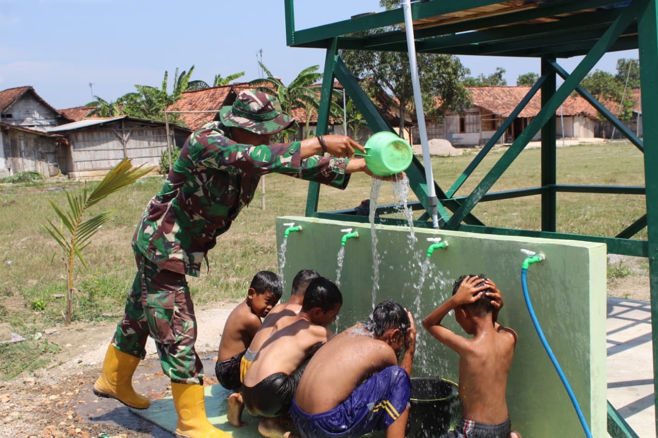 DISAMBUT GEMBIRA: Sejumlah anak-anak di Sidomulyo mandi dari air sumur bor program TMMD Reguler ke-122.