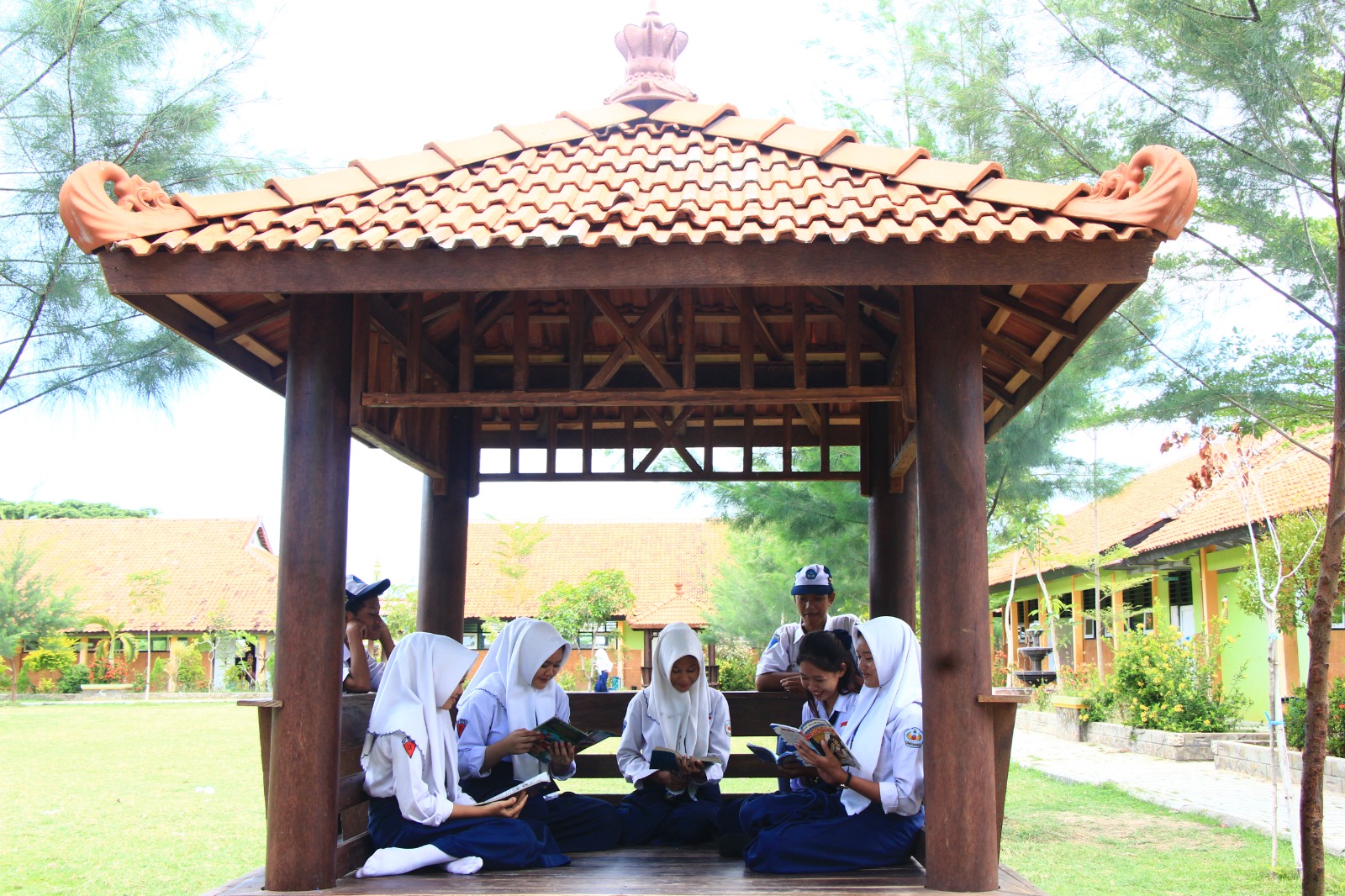 TINGKATKAN LITERASI: Siswa SMPN 2 Kragan menyempatkan waktu istirahat dengan membaca di areal gazebo di halaman dalam sekolah.