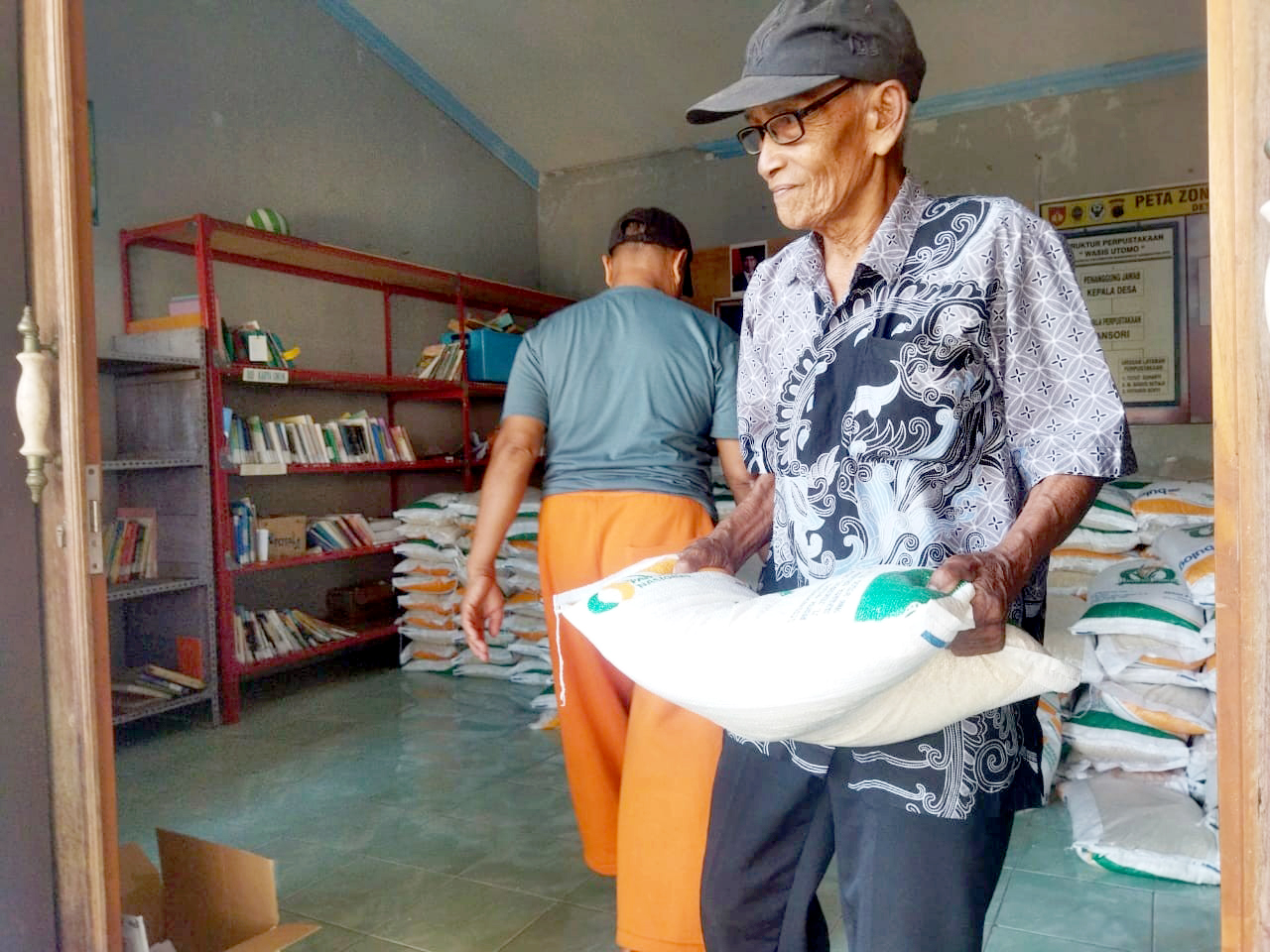 DIBANTU: Salah satu penerima bantuan mengambil beras di kantor balai Desa/Kecamatan Margorejo belum lama ini. (ANDRE FAIDHIL FALAH/RADAR KUDUS)   &nbsp;