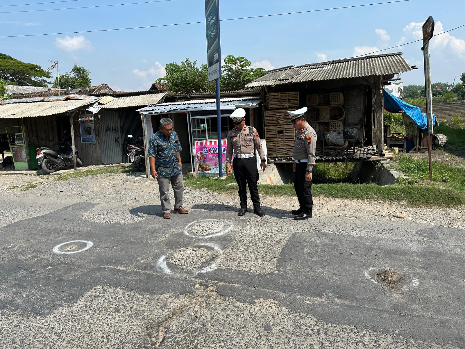 SURVEI JALAN: Satlantas Polres Grobogan menyurvei jalan berlubang di depan Pasar Nambuhan, Kecamatan Purwodadi, Grobogan. (INTAN MAYLANI SABRINA/RADAR KUDUS)