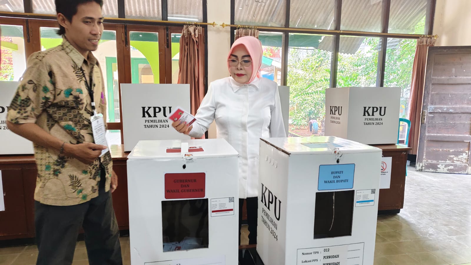 AJAK NYOBLOS &mdash; Bupati Grobogan Sri Sumarni memasukkan surat suara saat mencoblos di TPS 12 kantor KPH Purwodadi (27/11). (SIROJUL MUNIR/RADAR KUDUS)