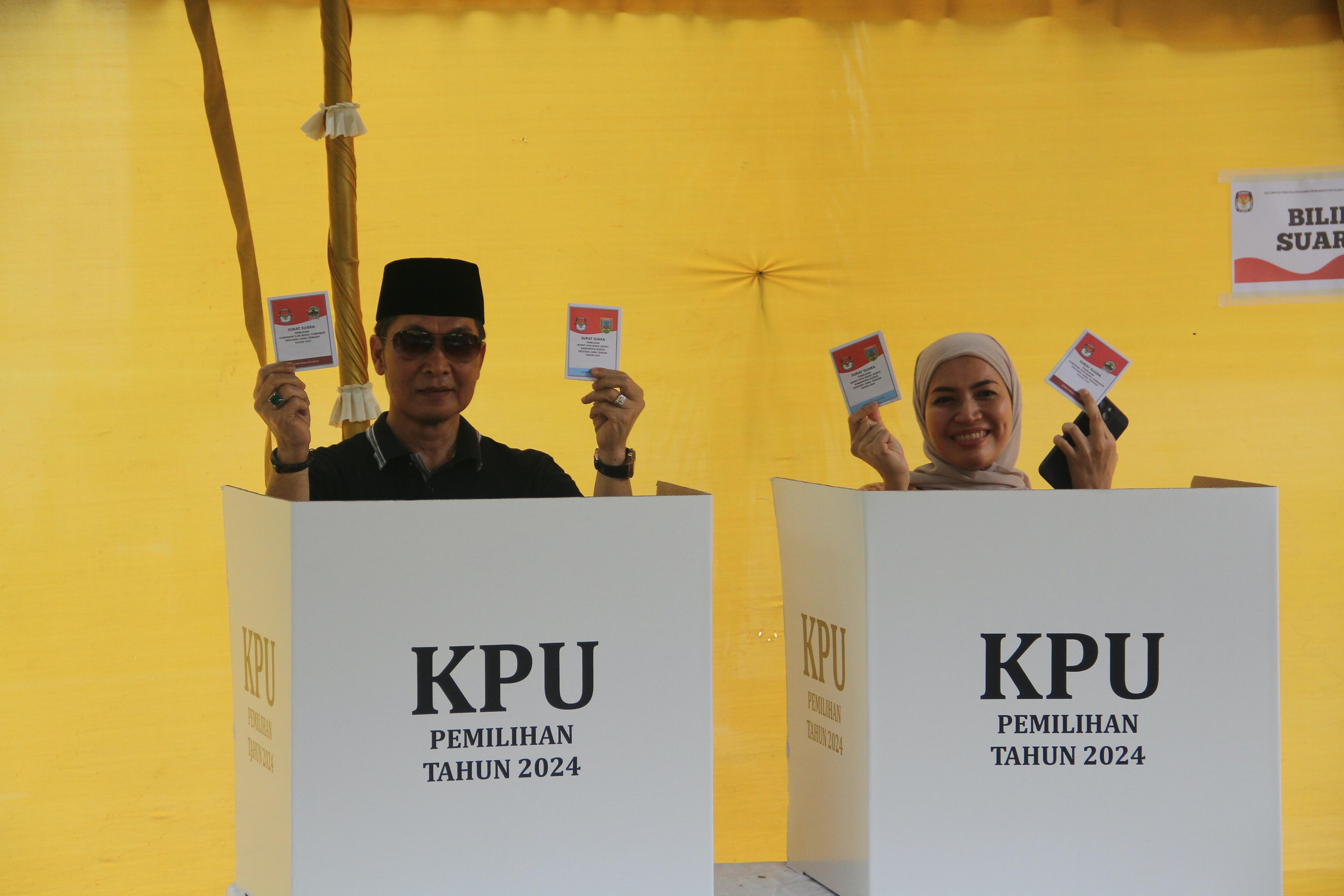 PESTA DEMOKRASI: Cabup Hartopo bersama istrinya Mawar menyalurkan hak pilihnya di TPS 21 di Perum Muria Indah. (GALIH ERLAMBANG W/ RADAR PATI)   &nbsp;