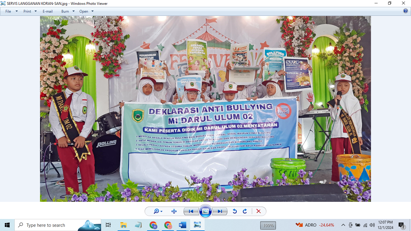 INDAH SUSANTI/RADAR KUDUS DEKLARASI: Siswa kelas V MI Darul Ulum 02 Ngembalrejo membawa spanduk bertuliskan Stop Bullying di atas panggung saat acara Festival Literasi Numerasi kemarin.