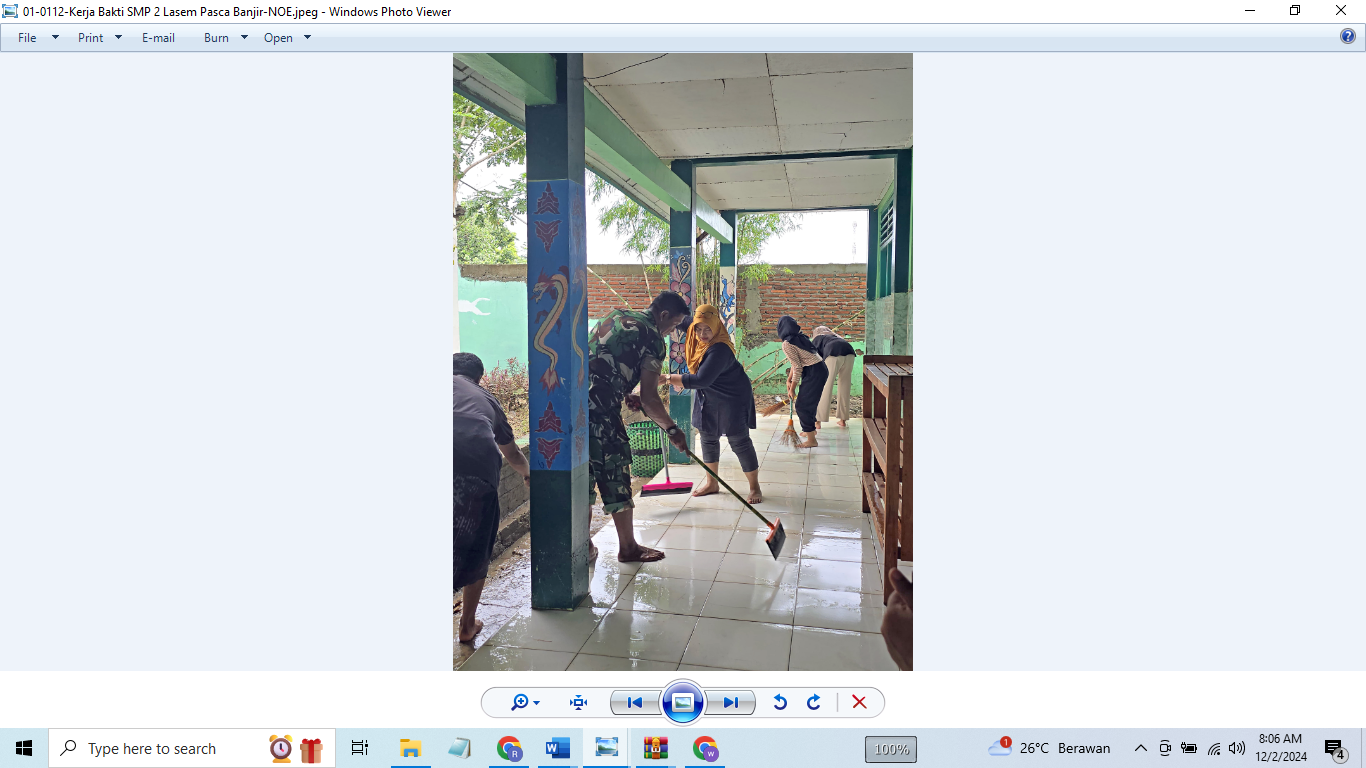 SUDAH SURUT: Pegawai SMPN 2 Lasem  membersihkan halaman sekolah itu kemarin, usai kebanjiran Sabtu (30/12). (WISNU AJI/RADAR KUDUS)