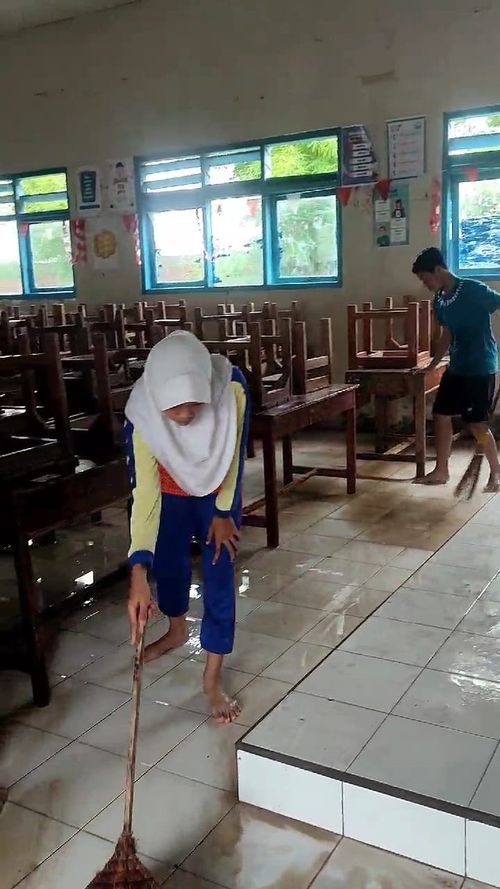 BERSIHKAN LUMPUR: Siswa SMPN 2 Lasem bersihkan sisa lumpur banjir hari Minggu lalu. (DOK.RADARPATI.ID)