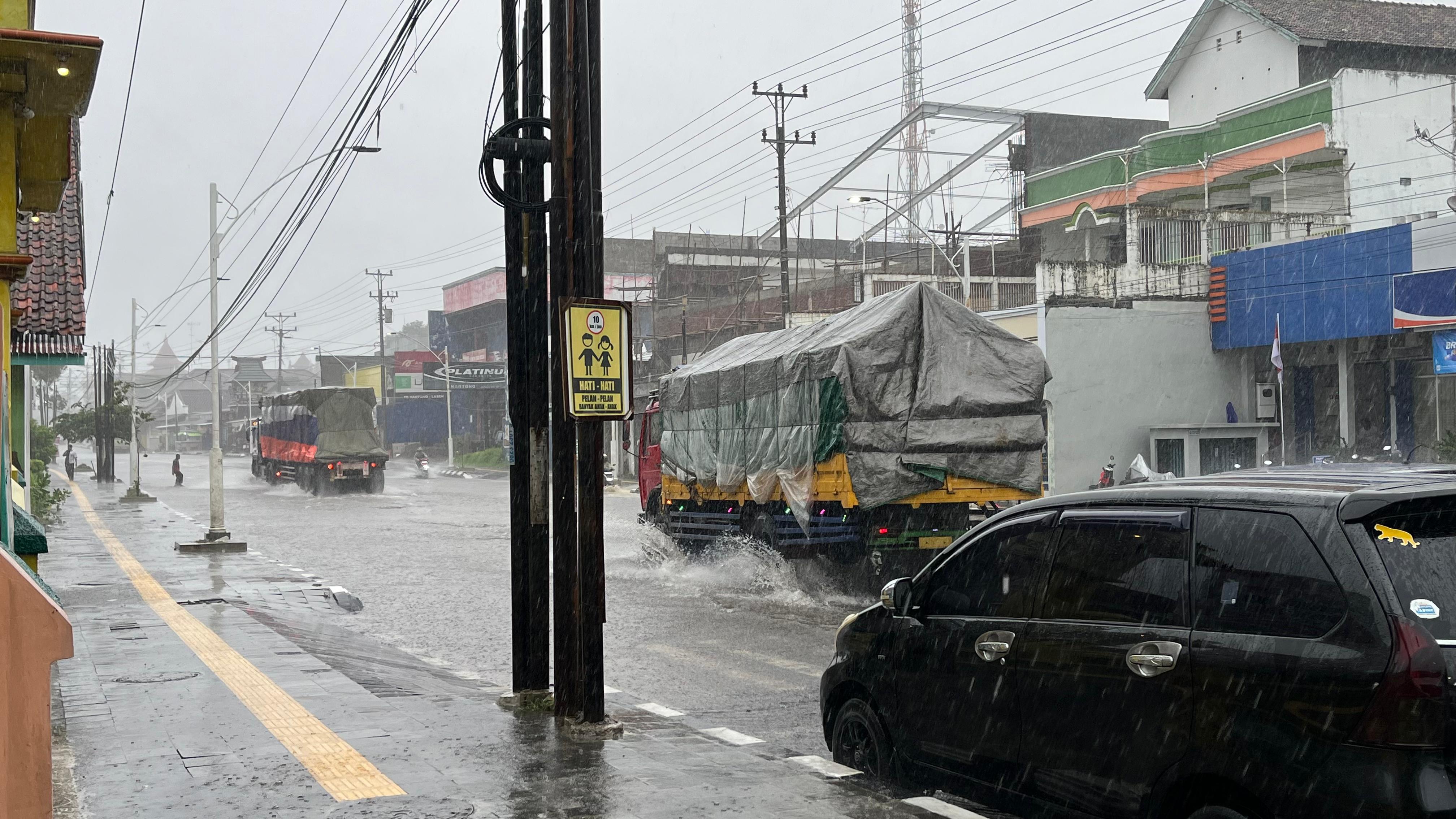 TERJANG GENANGAN: Sejumlah kendaraan besar menerjang genangan air di Jalan Pantura Lasem kemarin.