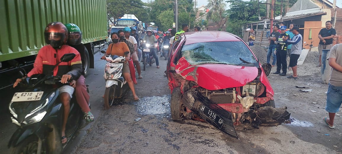 RINGSEK: Pengguna jalan melewati mobil yang terlibat laka di jalan Pati-Juwana pada Jumat (13/12)