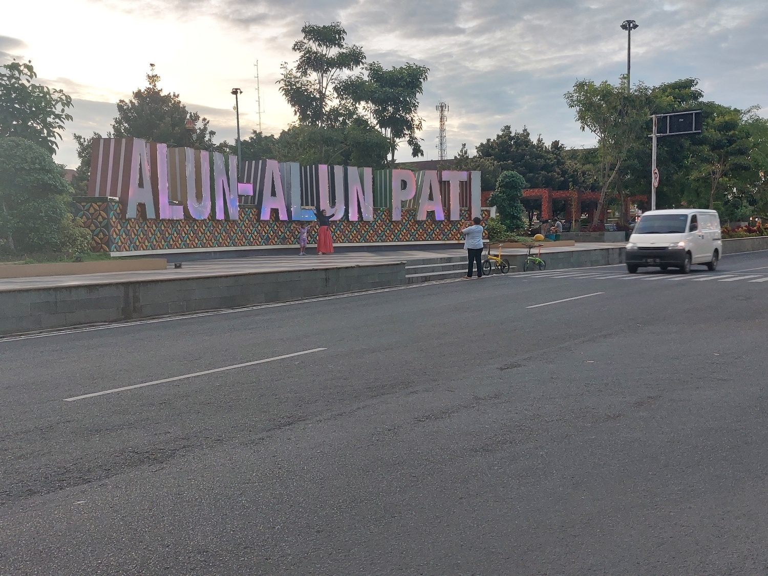LEWAT: Pengguna jalan melintasi Alun-alun Simpang Lima Pati akhir pekan lalu. (ANDRE FAIDHIL FALAH/RADAR PATI)