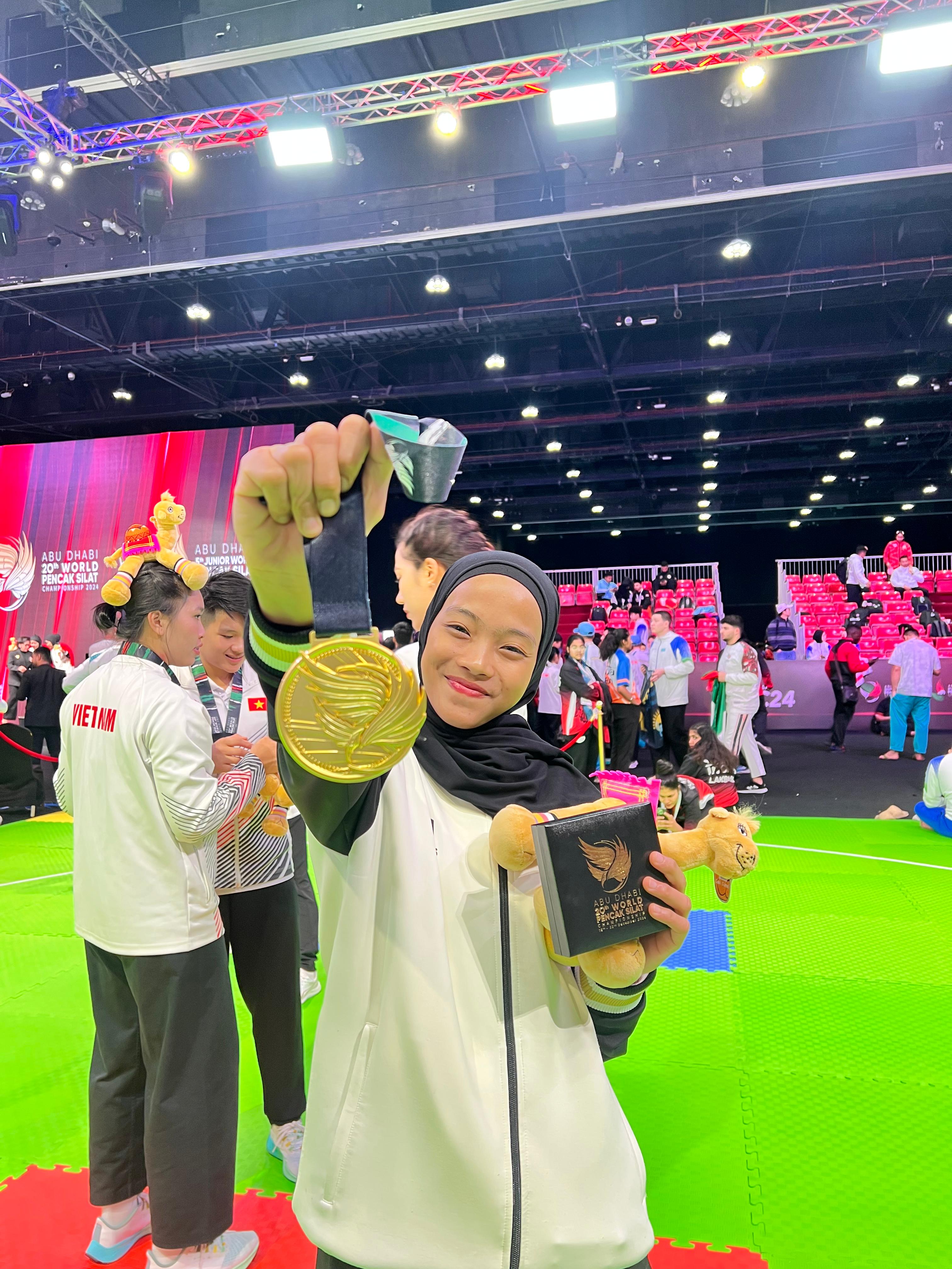 MEMBANGGAKAN: Pesilat asal Kudus Safira Dwi Meilani menunjukkan medali emasnya usai menjuarai World Pencak Silat Championship 2024 Abu Dhabi. (SAFIRA UNTUK RADAR PATI)
