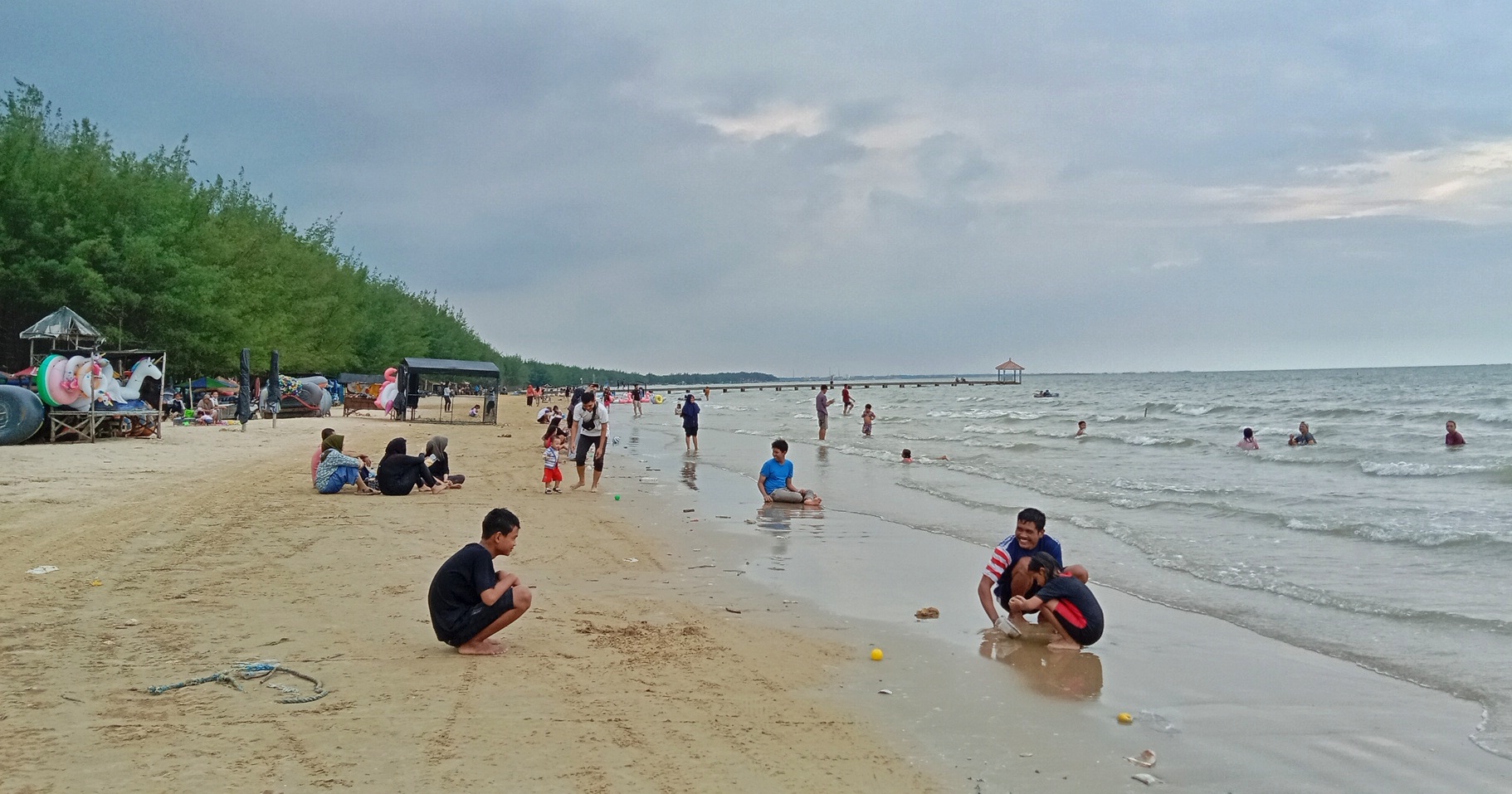 BERLIBUR: Wisatawan berada di area Pantai Karangjahe baru-baru ini. (VACHRI RINALDY L/RADAR KUDUS)