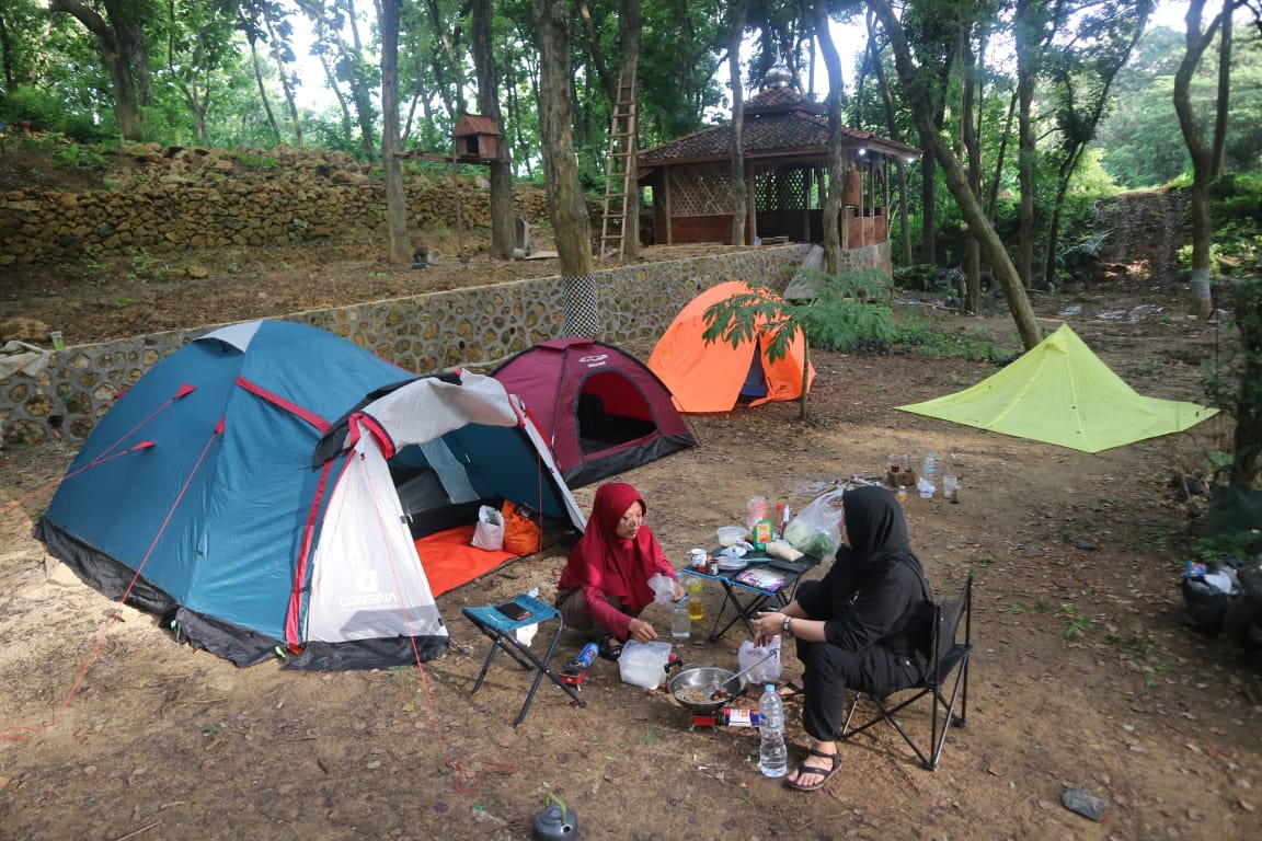 ALTERNATIF: Pengunjung sedang berkemah di camping ground di tengah hutan sonokeling di Desa/Kecamatan Sukolilo. (ACHMAD ULIL ALBAB/RADAR PATI)