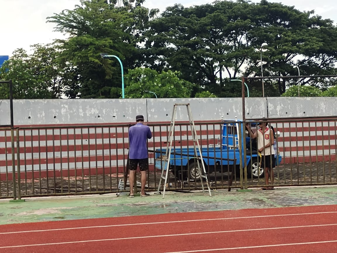 Pekerja sedang memperbaiki pagar di tribun sebelah utara yang rusak saat kericuhan suporter usai laga menjamu Persipura Jayapura.