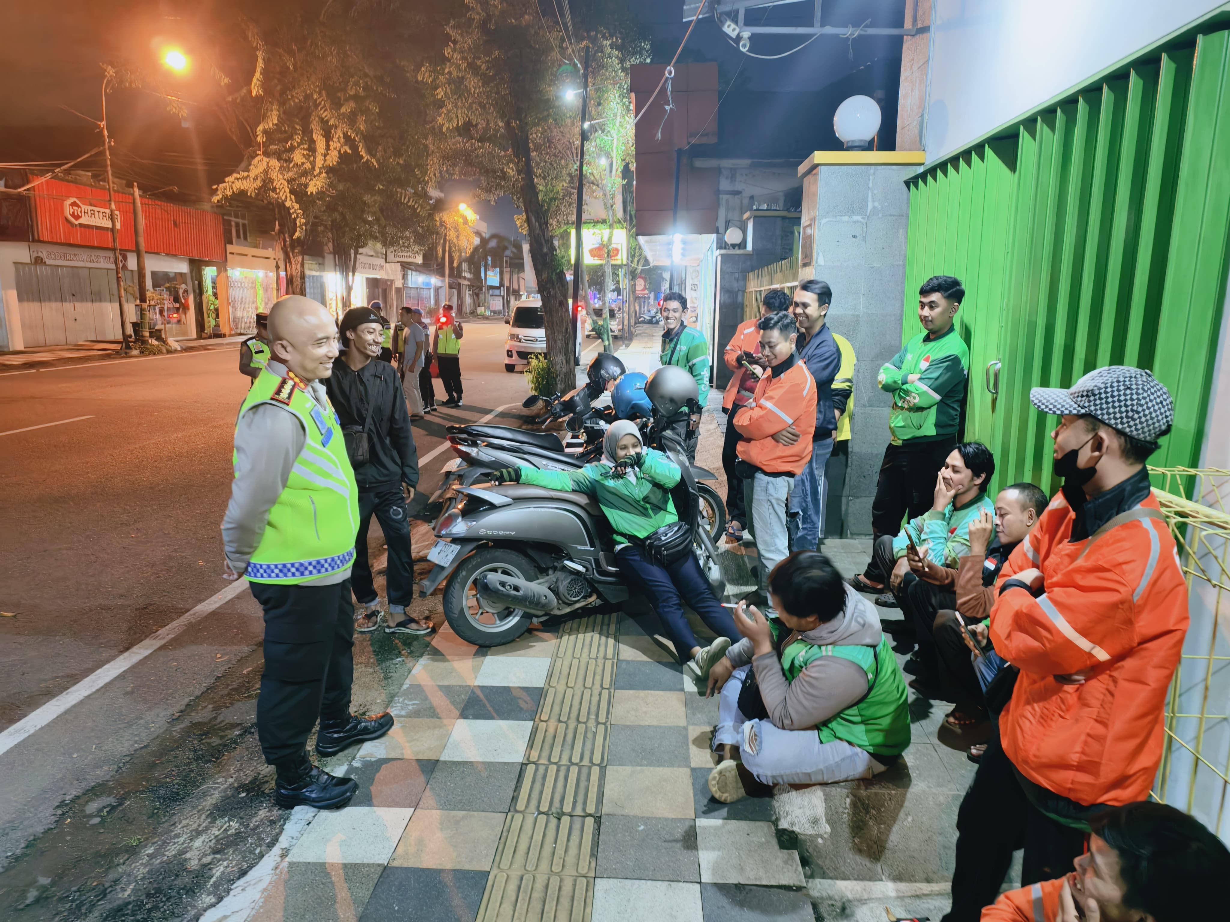DISAMBANGI: Kapolresta Pati Kombes Pol Andhika Bayu Adhittama memberikan bungkus nasi kepada ojol di sela patroli sahur. (HUMASRESTA PATI UNTUK RADAR KUDUS)