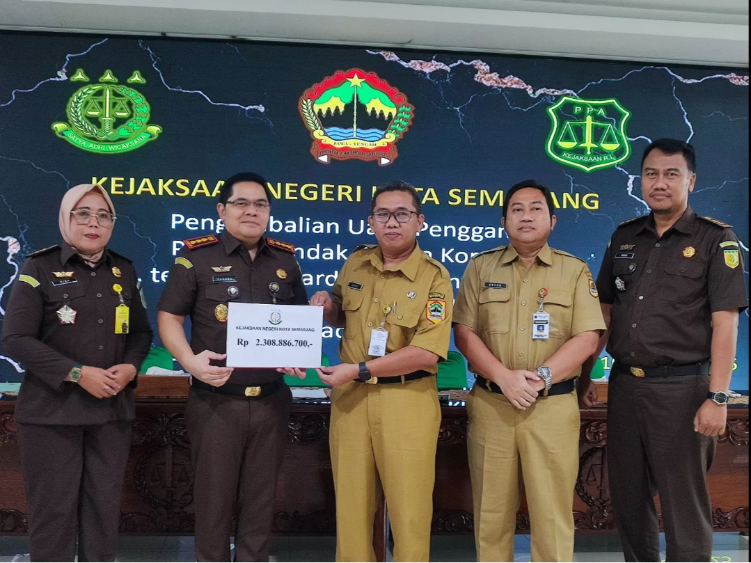 PENYERAHAN: Kejari Kota Semarang Candra Saptaji saat menyerahkan uang secara simbolis Kabid Perbendaharaan dan Aset Daerah BPKAD Provinsi Jawa Tengah, Sanadi, Senin (10/3). (IDA FADILAH/RADARPATI.ID)